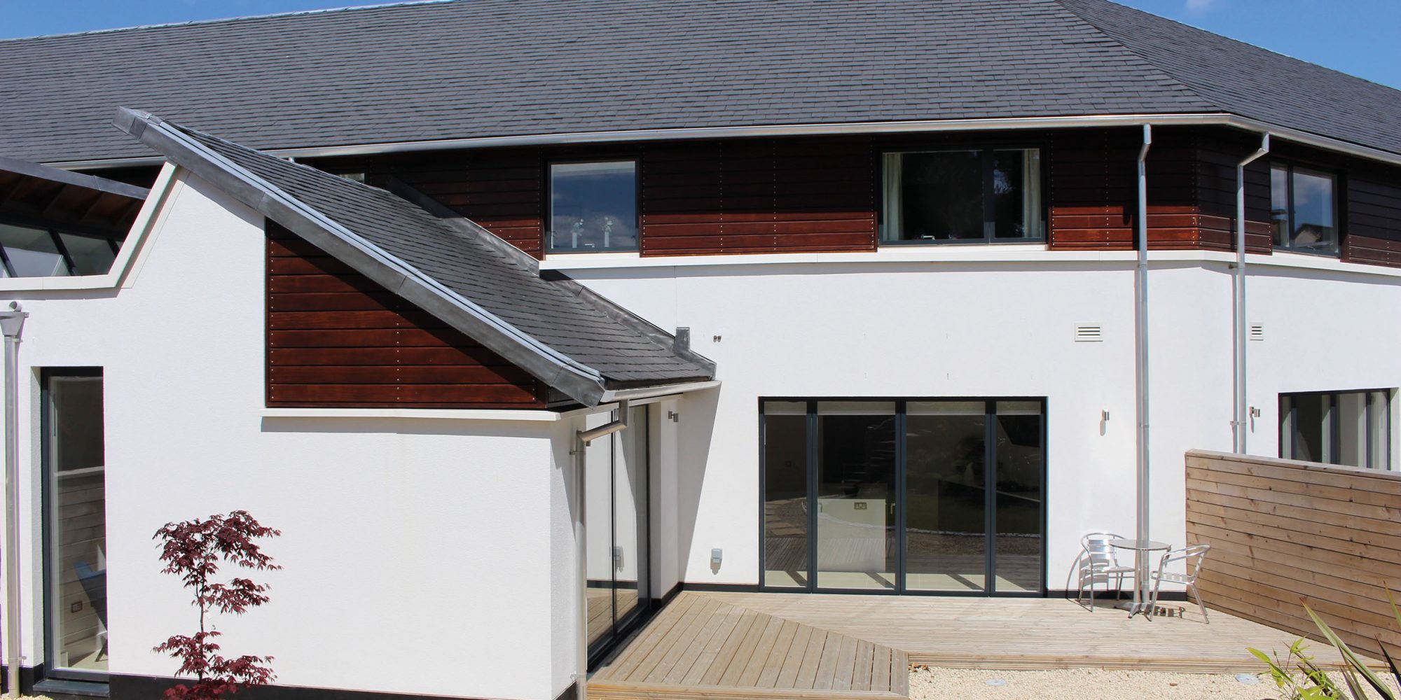 Rear of Caer Amon Crescent house showing garden, deck and patio doors.
